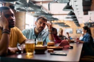 Man experiencing drowsiness at bar after mixing alcohol and Zoloft 