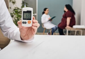 Device with low blood sugar reading in front of patient and doctor in background