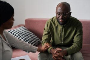 Man speaking with medical practitioner to find appropriate support for sleep or mood disorders instead of self-medicating with alcohol and trazodone