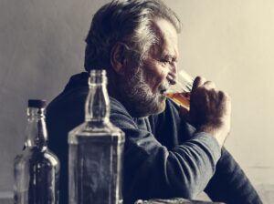 Man with faraway expression drinking alcohol to symbolize Wernicke-Korsakoff Syndrome